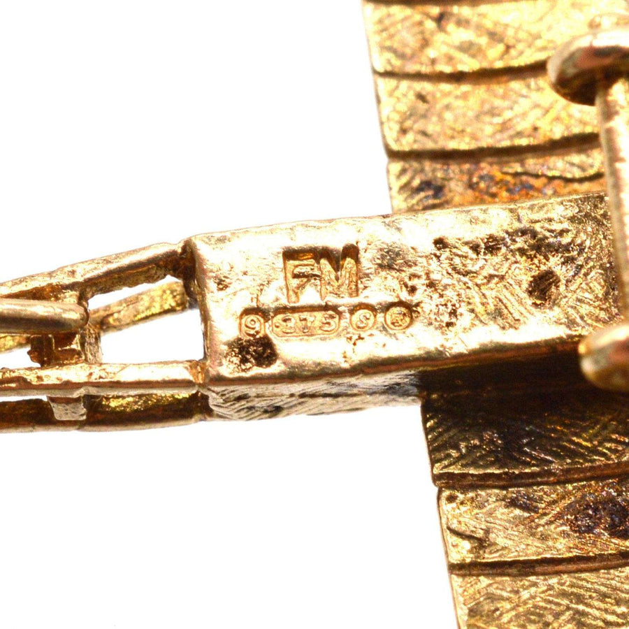 Close-up of 9ct gold vintage Aerolane pendant marking FM, showcasing exquisite craftsmanship and detailing.