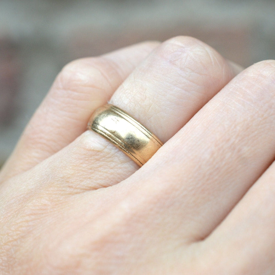 1970s 9ct gold wedding ring with decorated edge displayed on a hand for a classic bridal look.