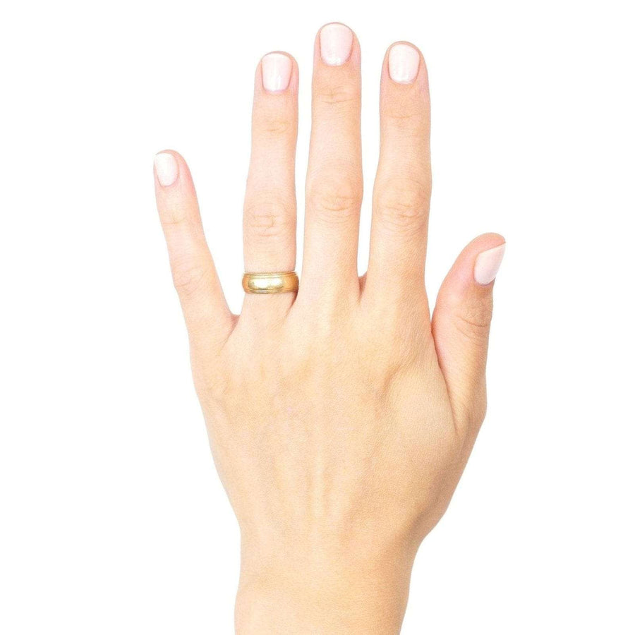 Hand wearing a 1970s 9ct gold wedding ring with decorated edges, showcasing a stylish design.