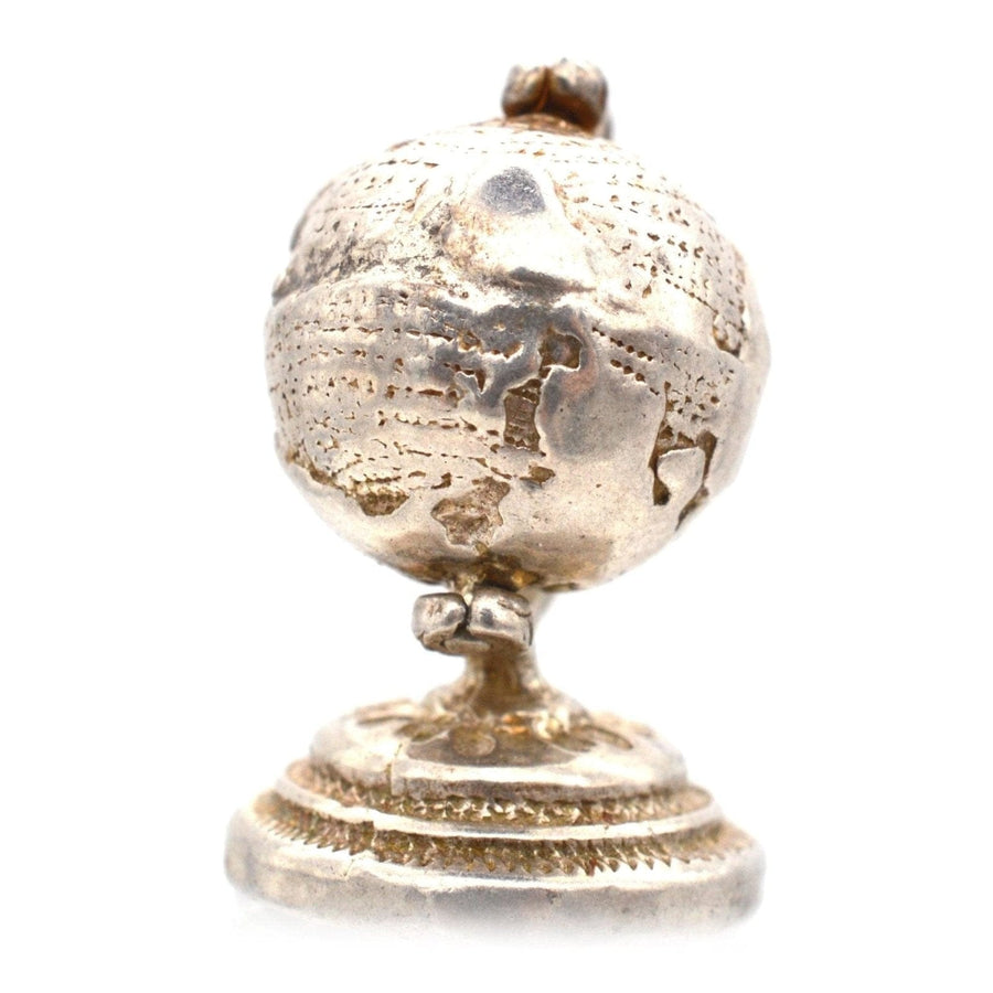 1970s silver antique globe charm pendant, spinning globe design, travel-inspired accessory.