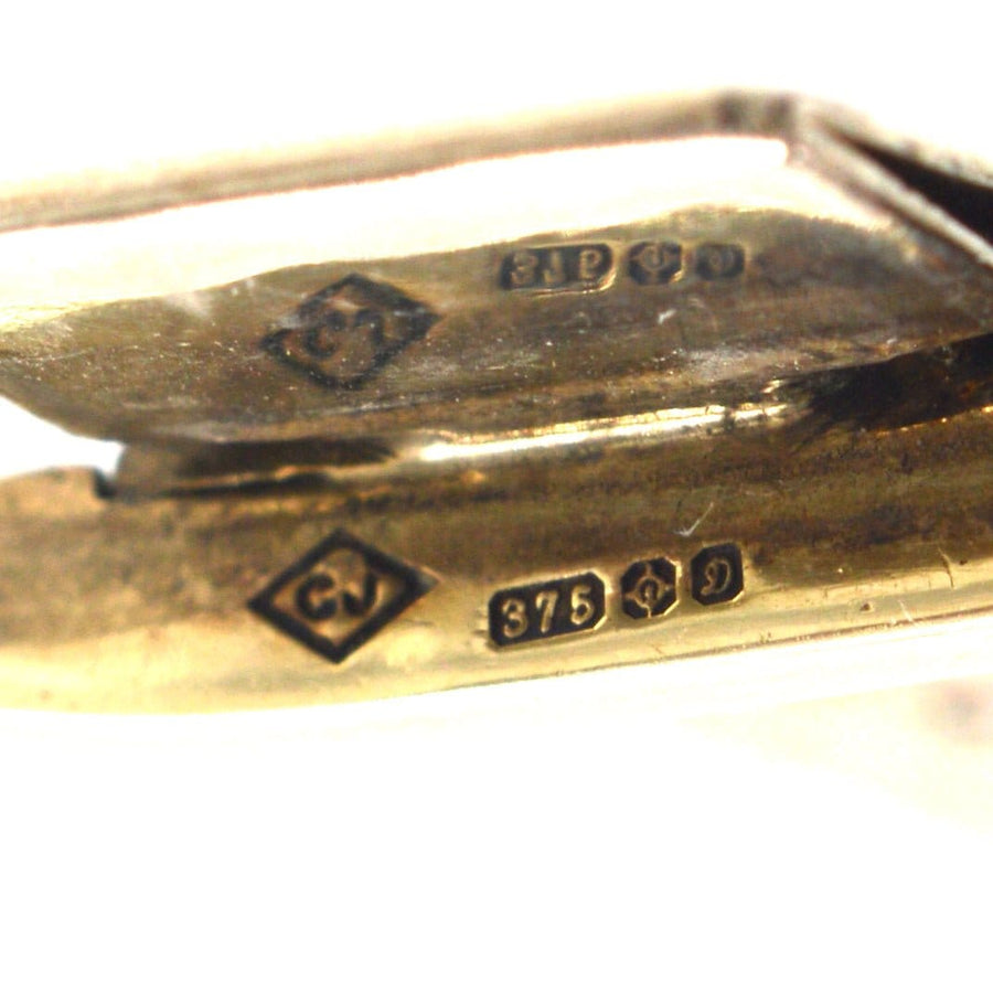 Close-up of hallmark stamps on a 9ct gold weave bracelet showcasing quality and craftsmanship.