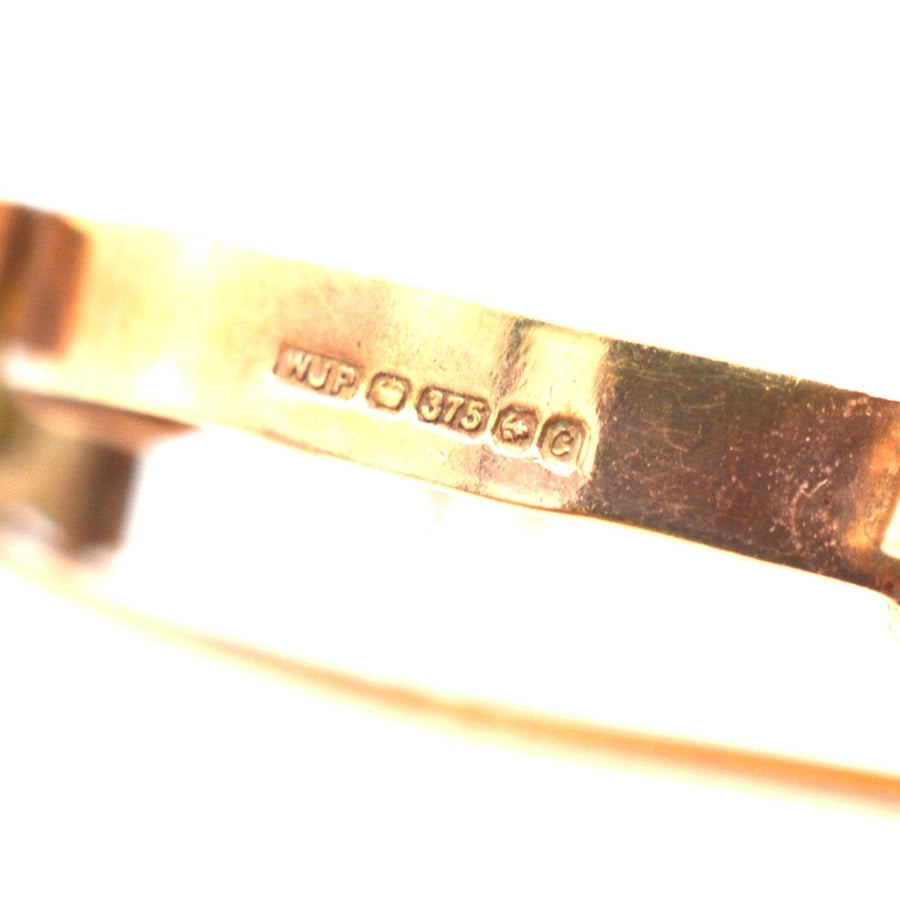 Close-up of the hallmark on a 9ct gold brooch mount for a 22ct gold sovereign coin.