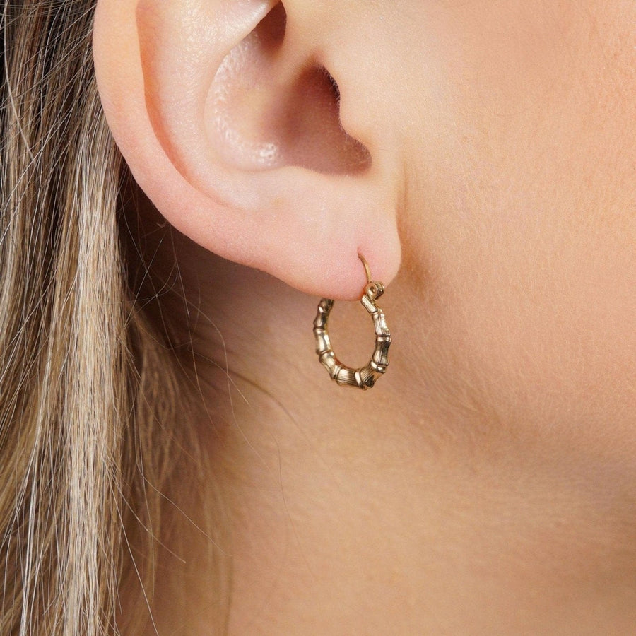 1990s vintage 9ct gold hoop earrings with bamboo texture, perfect for everyday wear, seen on an ear.