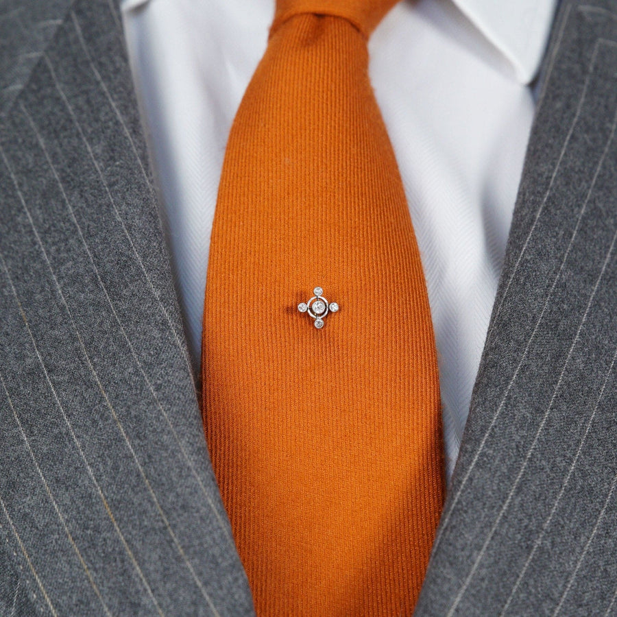 Art Deco 15ct gold and diamond circular tie pin on an orange silk tie, showcasing its elegant design and diamond arrangement.