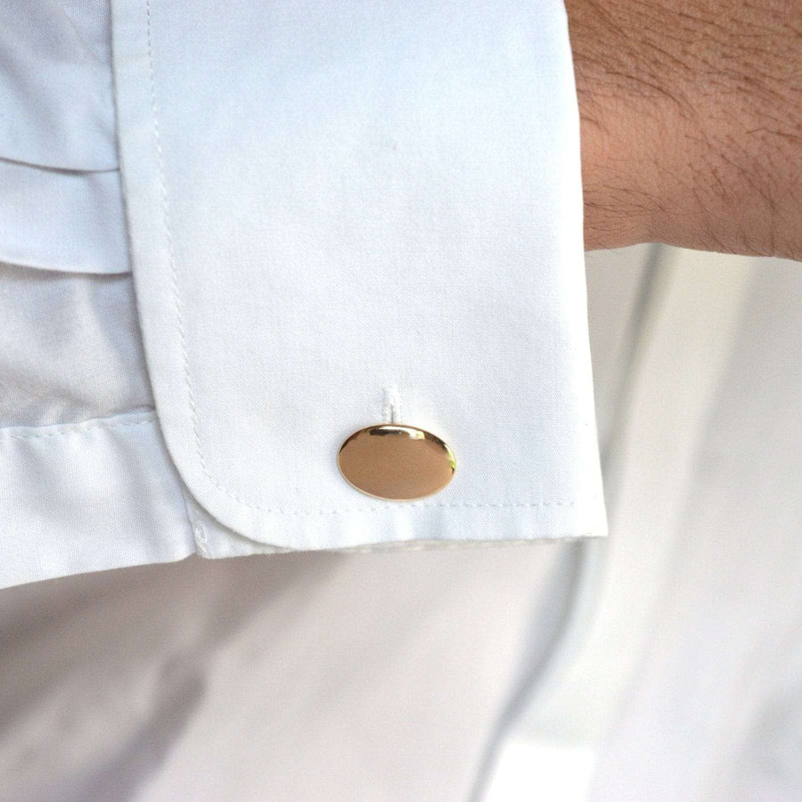 Art Deco 18ct gold plain oval cufflink displayed on a white shirt cuff, showcasing a timeless elegant design.