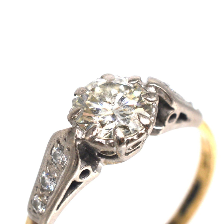 Art Deco 18ct gold and platinum diamond solitaire ring with diamond shoulders, featuring a vibrant 3/4 carat center diamond.