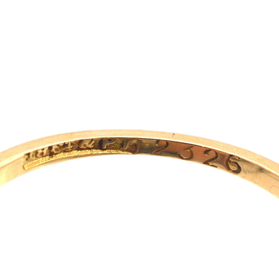 Close-up of the inner band of an Art Deco 18ct gold ring with engraved markings and unique design details.