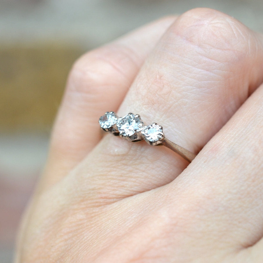Art Deco 18ct gold and platinum three stone diamond ring showcased on a hand, vintage design from the 1930s.