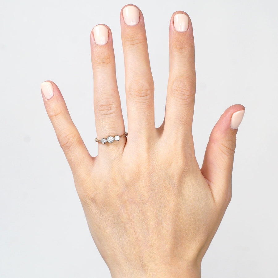 Art Deco 18ct gold and platinum three stone diamond ring showcased on a hand, ideal for engagements.