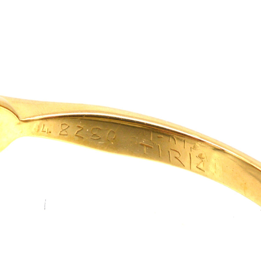 Detail of the inside engraving on a gold ring, showcasing the purity mark and design details.