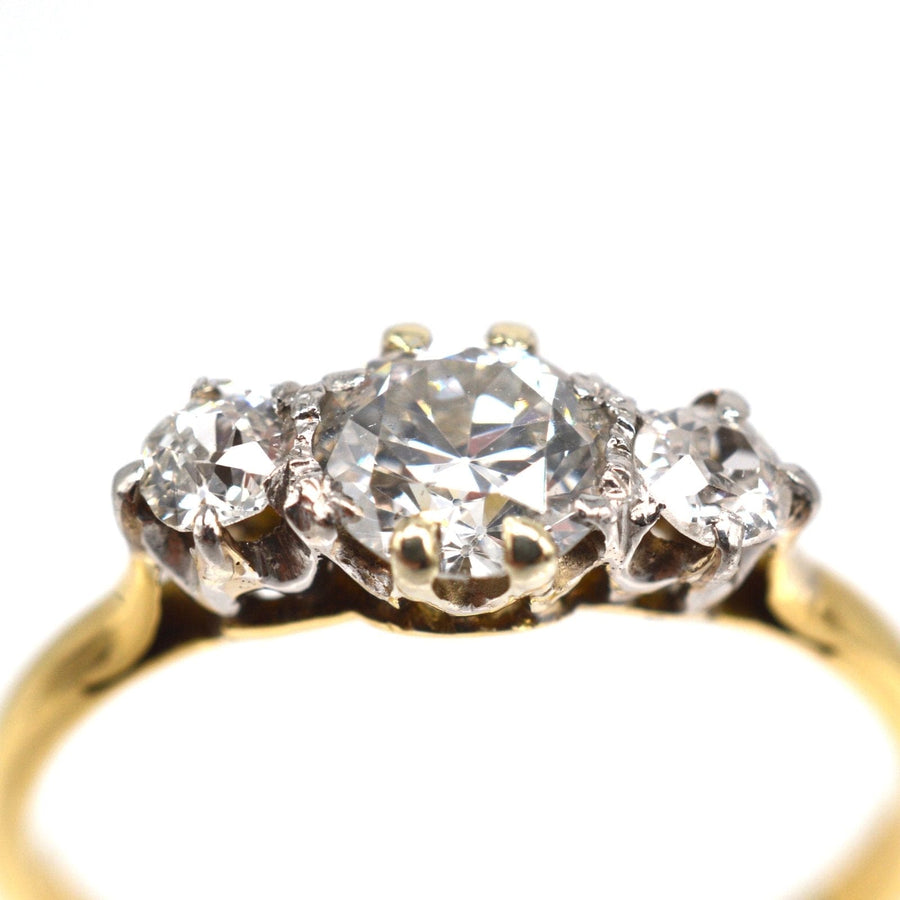 Art Deco 18ct gold three stone ring featuring a central transitional cut diamond and two flanking diamonds, totaling 0.75 carats.