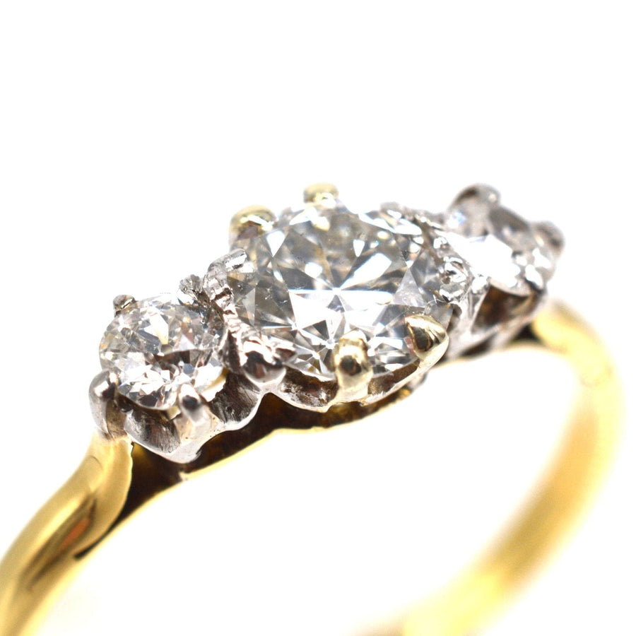 Art Deco 18ct gold three stone ring featuring a central transitional cut diamond with two smaller diamonds.