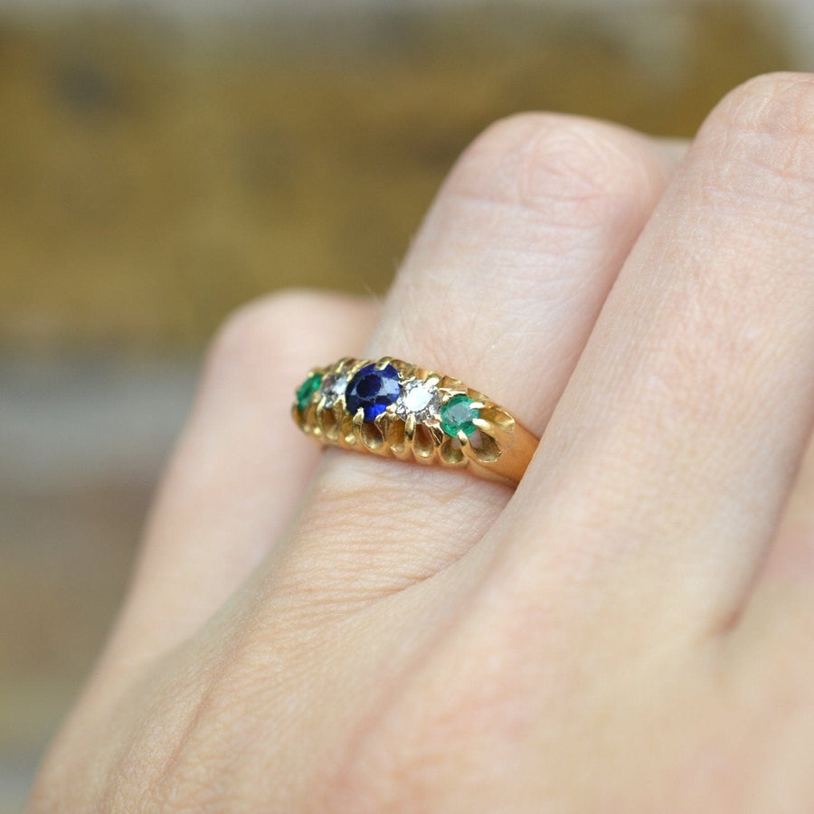 Art Deco 18ct gold Tutti Frutti ring with sapphire, emerald, and diamond gemstones worn on a hand.