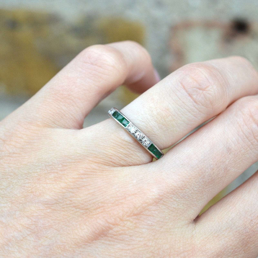 Art Deco 18ct white gold emerald and diamond eternity ring worn on a hand, showcasing its elegant design.