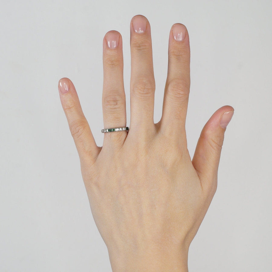 Art Deco 18ct white gold emerald and diamond eternity ring displayed on hand with natural nail polish.