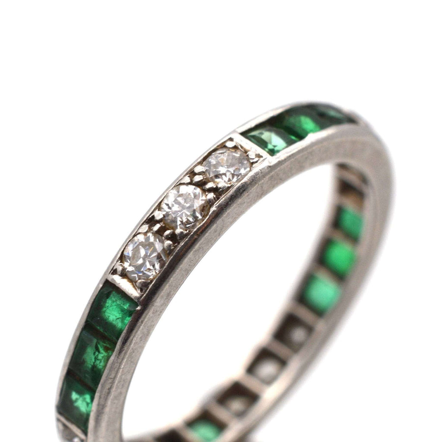 Art Deco 18ct white gold eternity ring featuring emerald and diamond accents, symbol of lasting love.