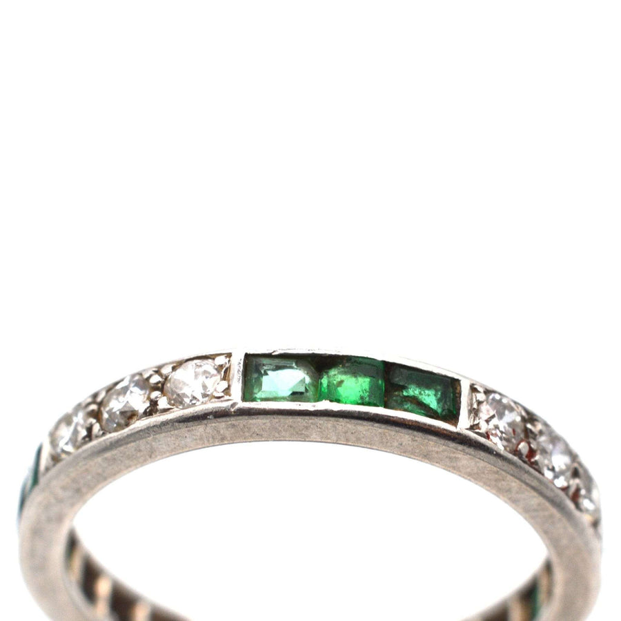 Art Deco 18ct white gold eternity ring featuring emerald and diamond stones, symbolizing enduring love.