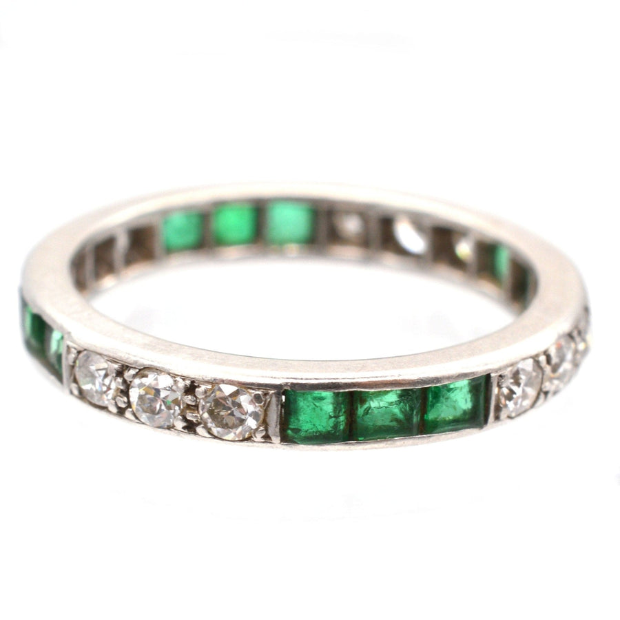 Art Deco 18ct white gold eternity ring featuring emerald and diamond accents, symbolizing everlasting love.