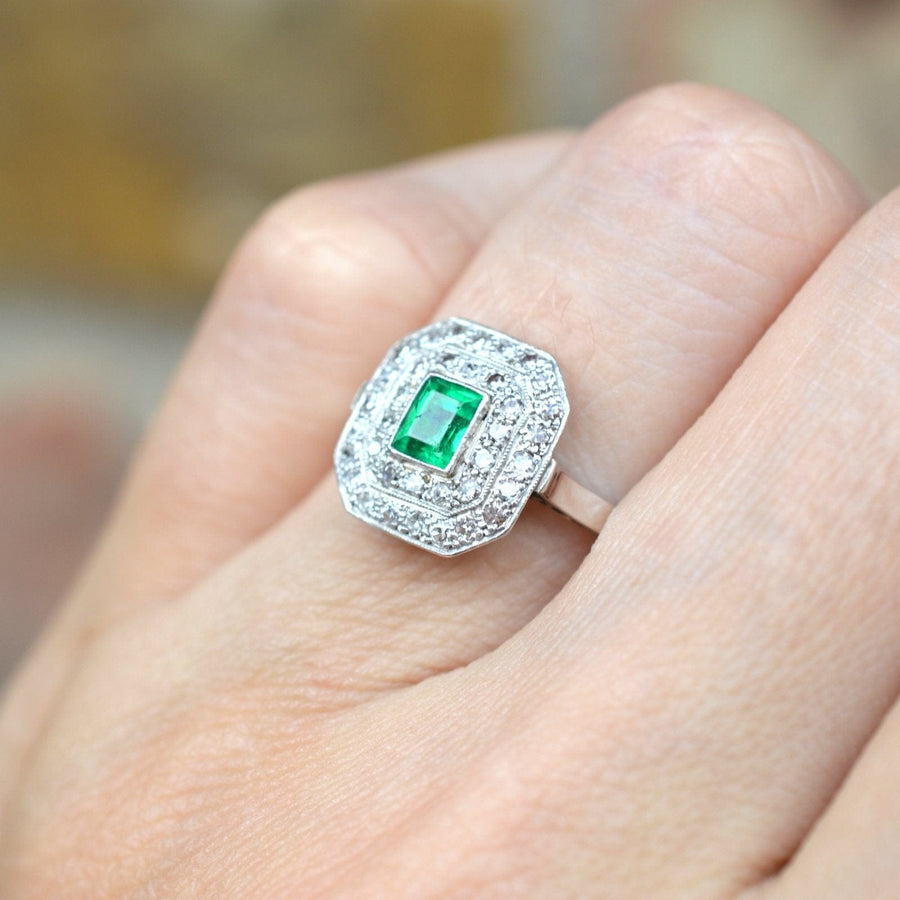 Art Deco 18ct white gold and platinum emerald and diamond ring worn on finger, showcasing vintage elegance.
