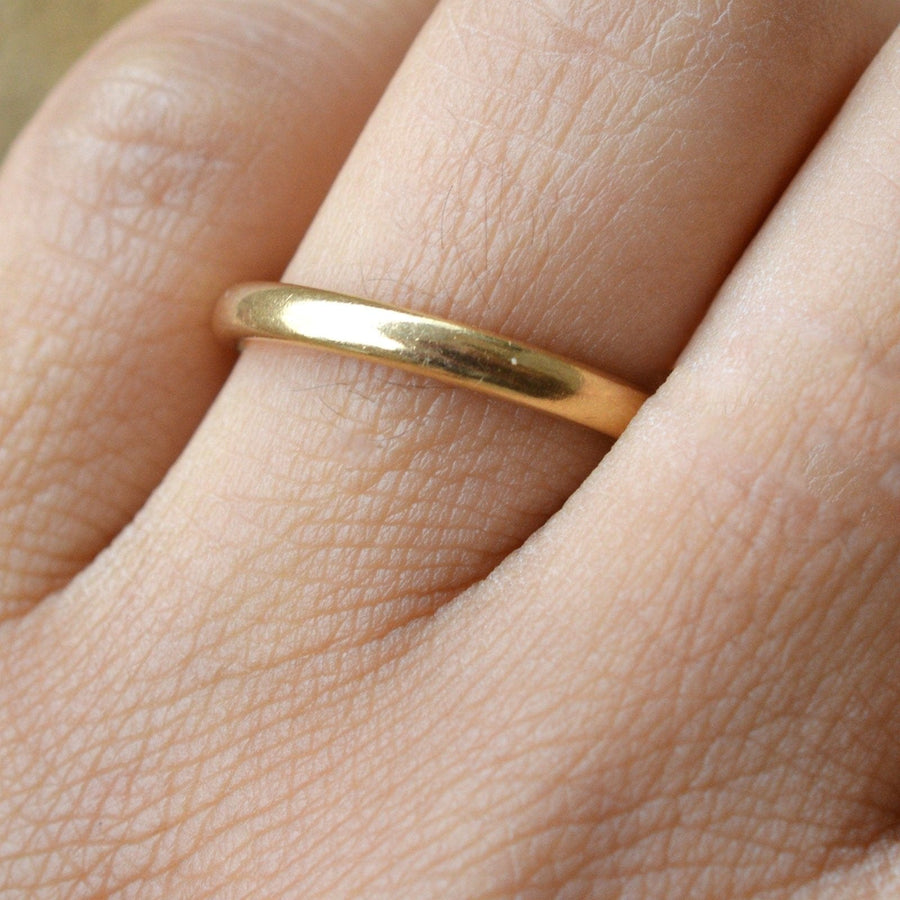 Art Deco 18ct yellow gold traditional court wedding ring on hand, 2.5mm width, polished finish for comfort.