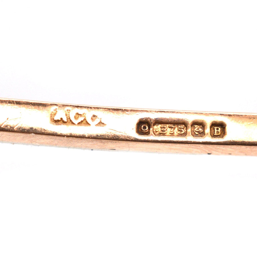Close-up of 9ct gold and platinum bar brooch hallmark, showing the manufacturer and purity marks in Birmingham.