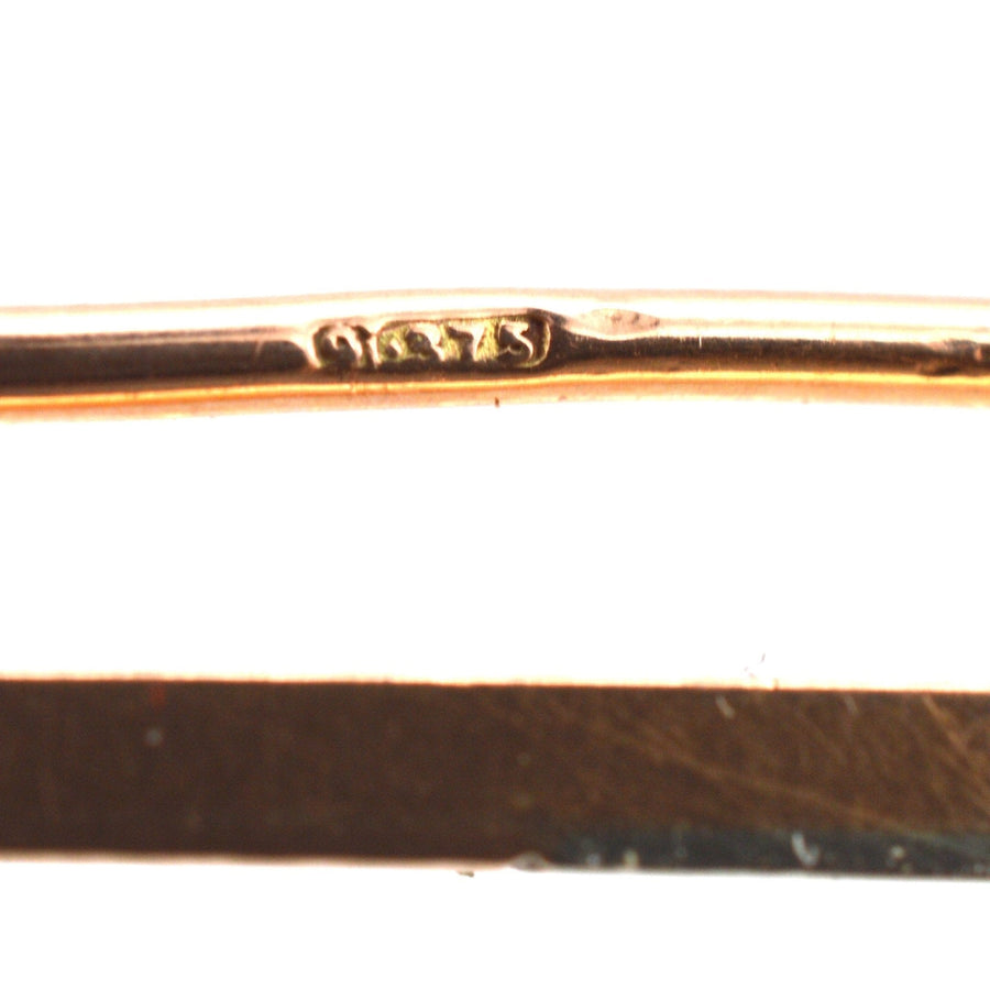 Close-up of the hallmark on a 9ct gold and platinum bar brooch, showcasing its craftsmanship and authenticity.
