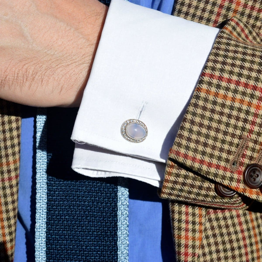 Stylish cufflinks featuring blue chalcedony, set in intricate 9ct gold, worn with a plaid suit jacket.