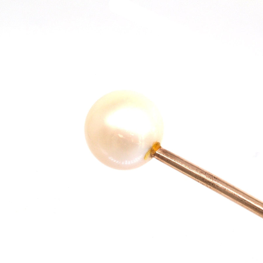 Close-up of a cultured pearl on a 9ct gold tie pin, showcasing its elegance and shine.