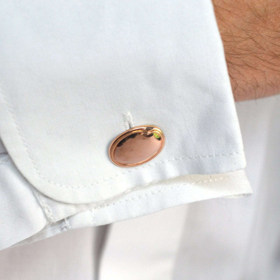 Art Deco 9ct gold plain oval cufflinks displayed on a white shirt cuff, showcasing their elegant design.