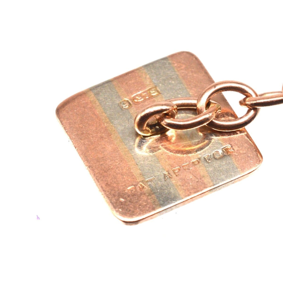 Close-up of 9ct gold cufflink back, showing engine-turned design and maker's mark, vintage Art Deco style.