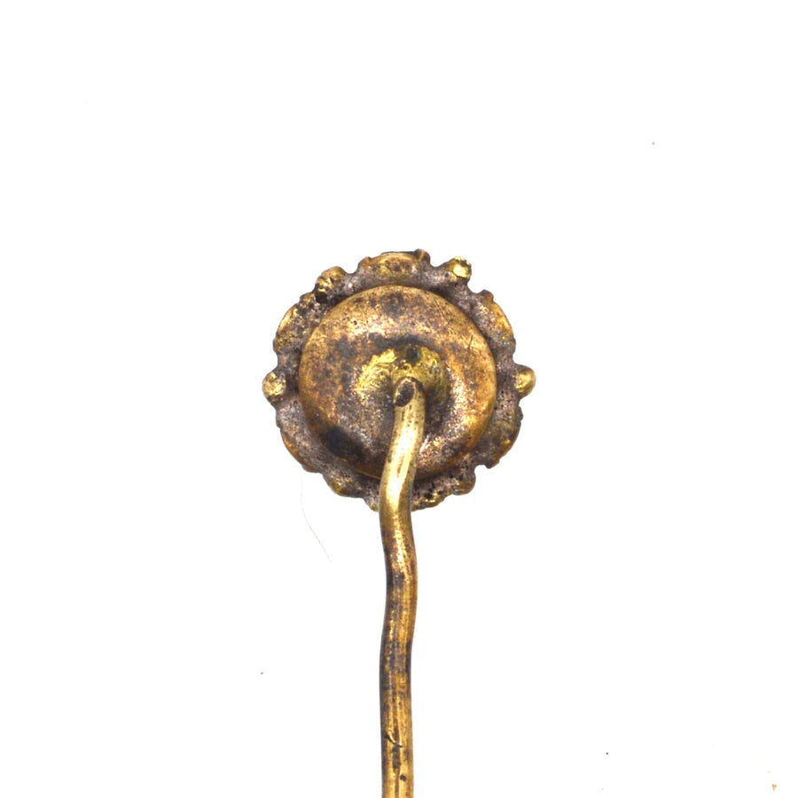 Close-up of vintage tie pin with intricate gold design and decorative flower-shaped head, perfect for classic styling.