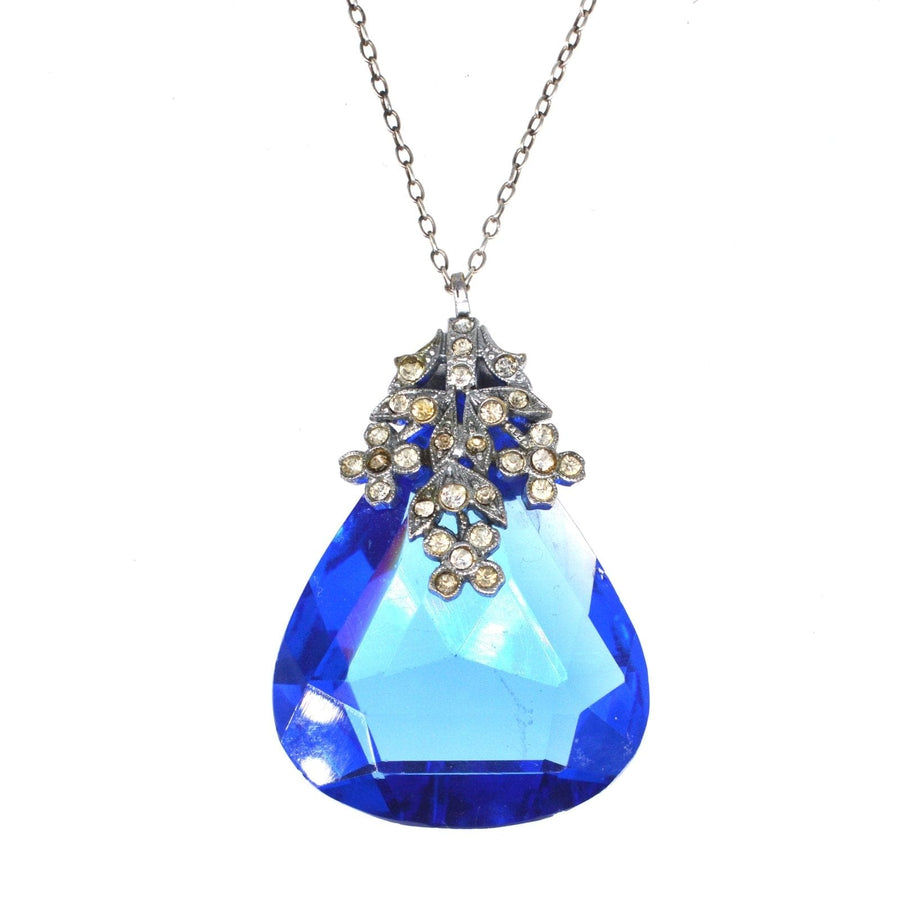 Art Deco blue paste pendant with white floral setting on silver chain, showcasing elegant costume jewellery design.