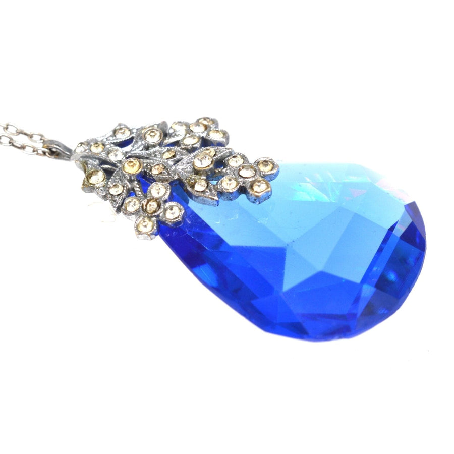 Art Deco blue paste pendant with floral setting on silver chain, showcasing stunning costume jewelry craftsmanship.