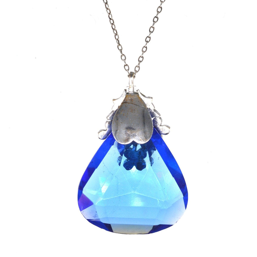 Art Deco pendant with blue paste stone on silver chain, featuring a floral white paste setting, colorful costume jewelry.