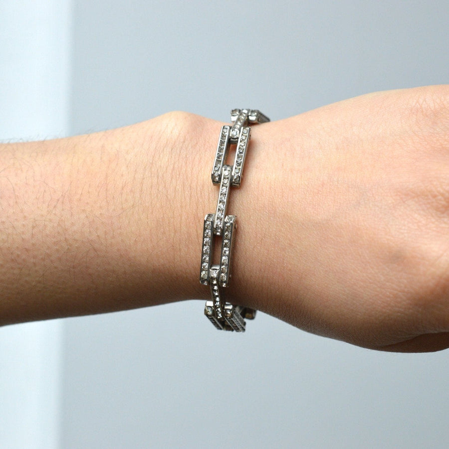 Art Deco German silver bracelet with white paste accents worn on a wrist, showcasing geometric design.