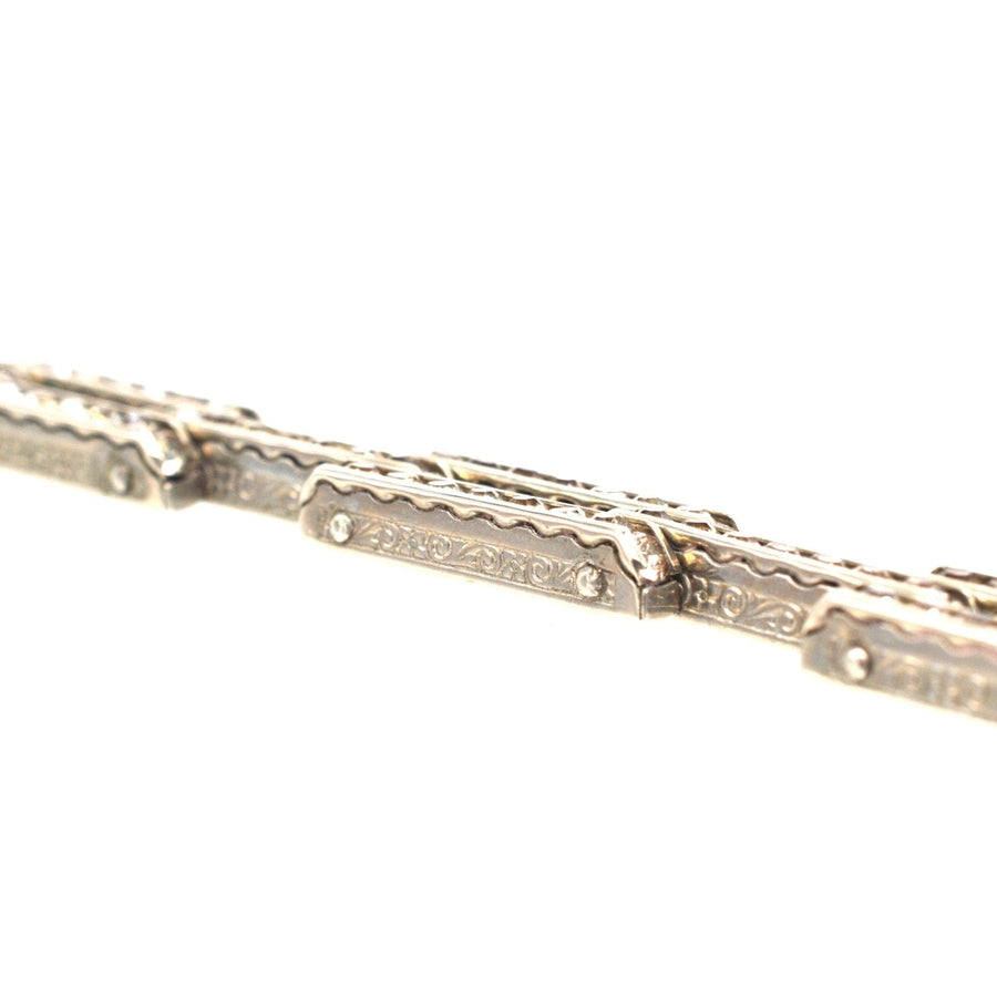 Art Deco German silver bracelet featuring intricate geometric designs and white paste accents, showcasing timeless elegance.