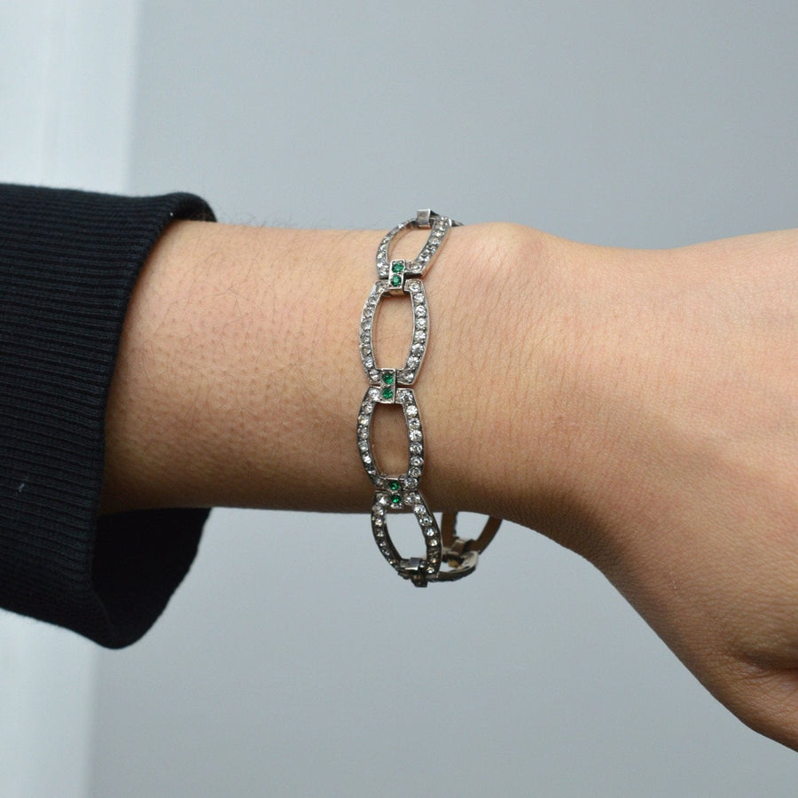Art Deco green and white paste bracelet displayed on a wrist, resembling diamonds and emeralds for elegant occasions.