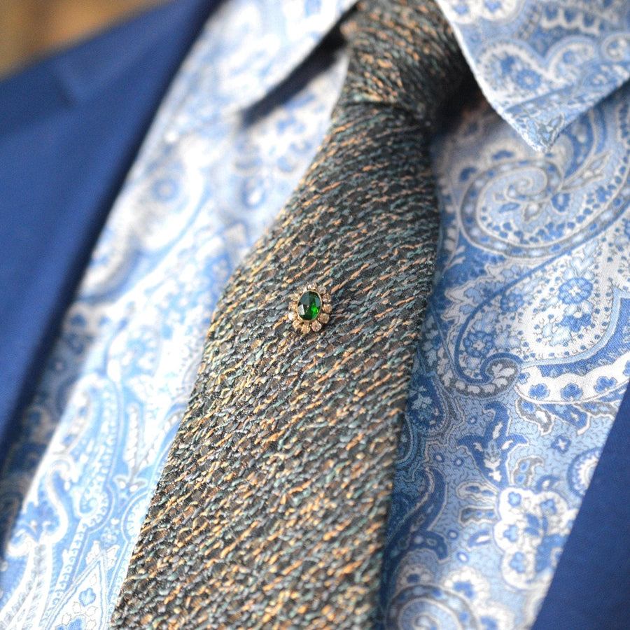 Stylish Art Deco green 'Emerald' and white paste cluster tie pin on a patterned silk tie, ideal for a refined look.