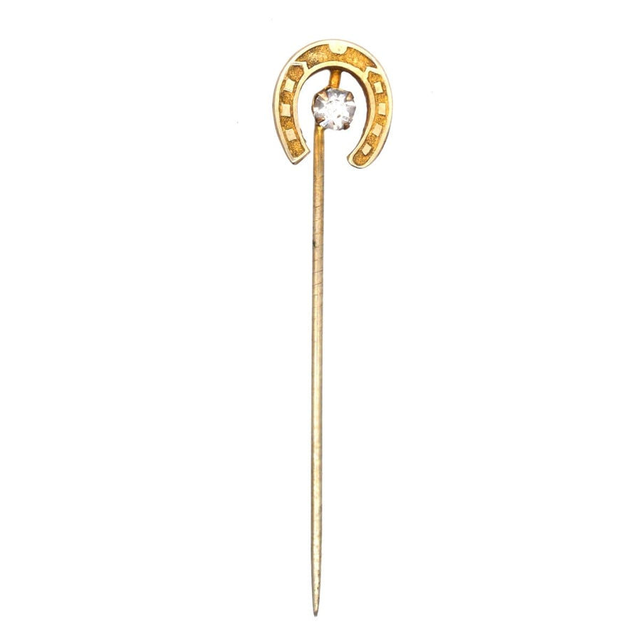 Art Deco horseshoe tie pin featuring a clear paste, symbolizing luck and protection, vintage European design.