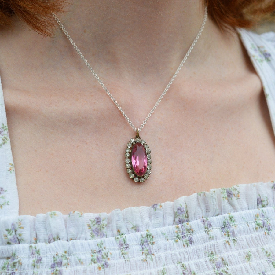 Art Deco pink and white paste cluster oval pendant worn on a silver chain, adding elegance and vintage charm.