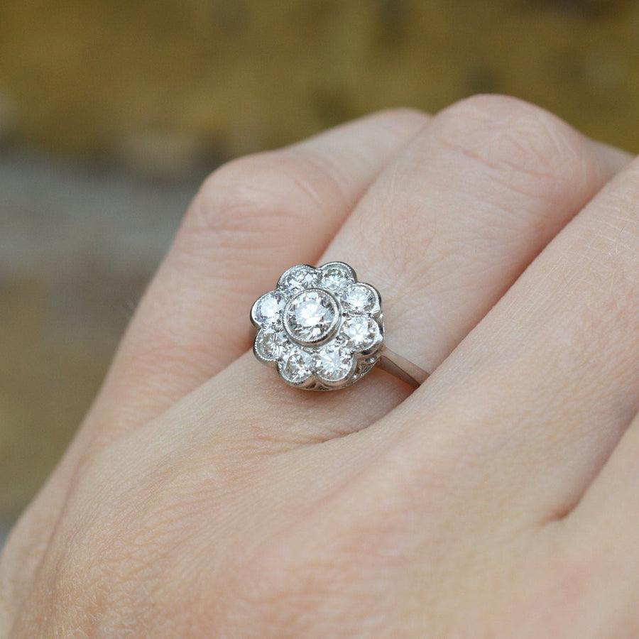 Art Deco platinum diamond cluster engagement ring featuring a floral design with sparkling diamonds.