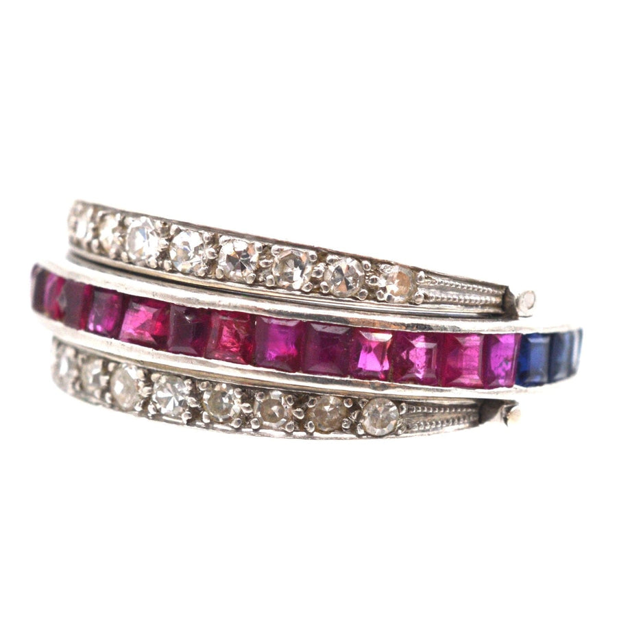 Art Deco platinum ring featuring diamonds, sapphires, and rubies with a versatile flip-over design.