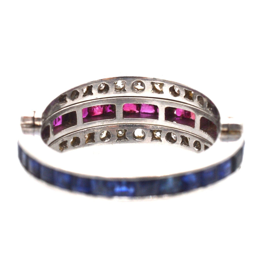 Art Deco platinum ring featuring diamonds, sapphires, and rubies, showcasing a unique flip-over design.