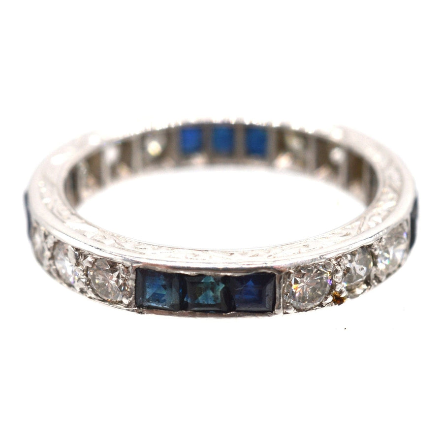 Art Deco platinum eternity ring featuring sapphires and diamonds, a timeless symbol of love and elegance.
