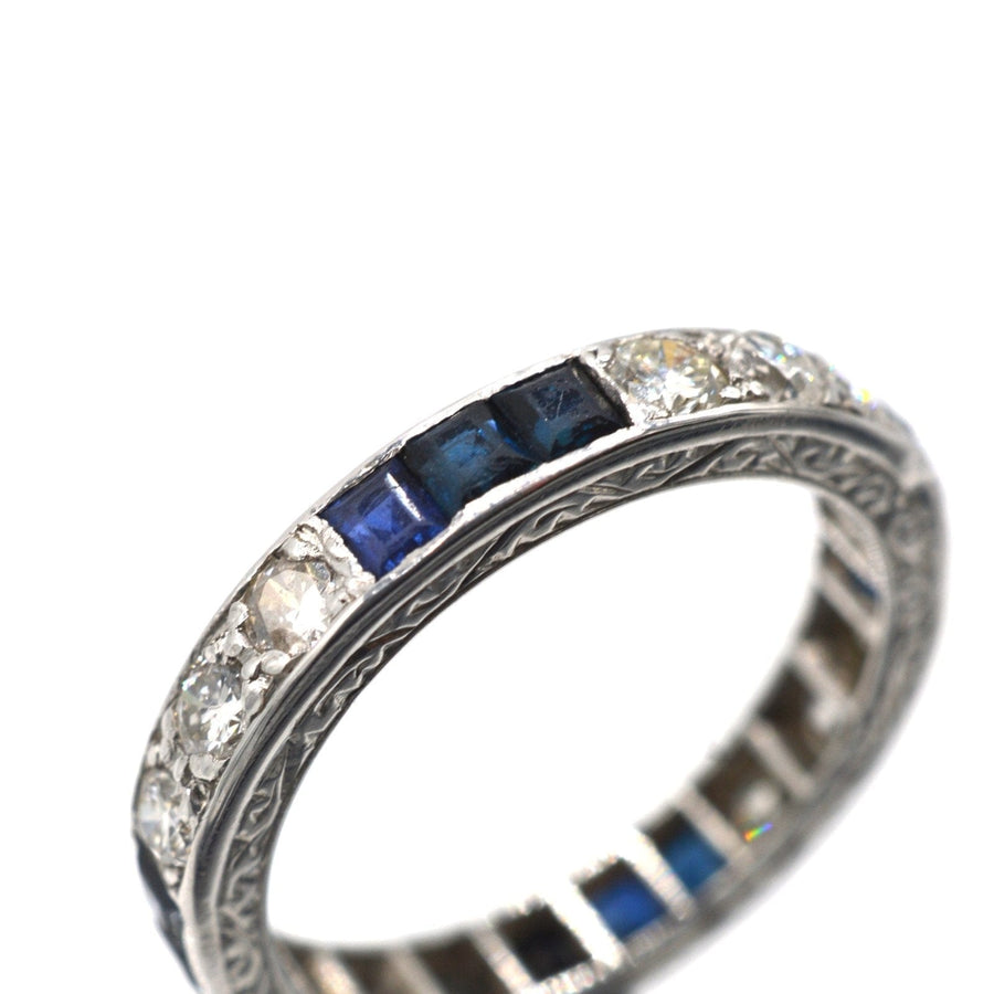 Art Deco platinum eternity ring featuring sapphires and diamonds, symbolizing lasting love.