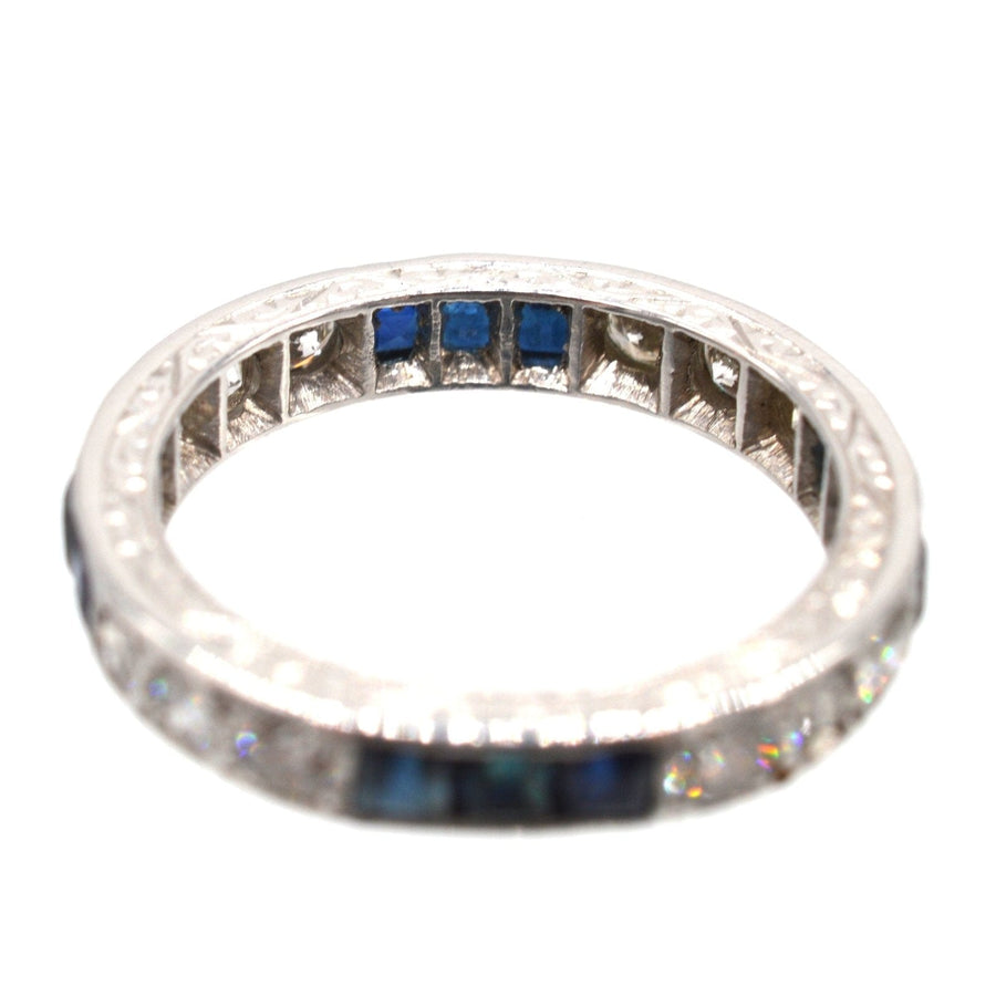 Art Deco platinum eternity ring featuring sapphires and diamonds, showcasing exquisite craftsmanship.
