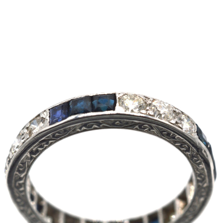 Art Deco platinum eternity ring featuring sapphires and diamonds, a timeless symbol of love and elegance.