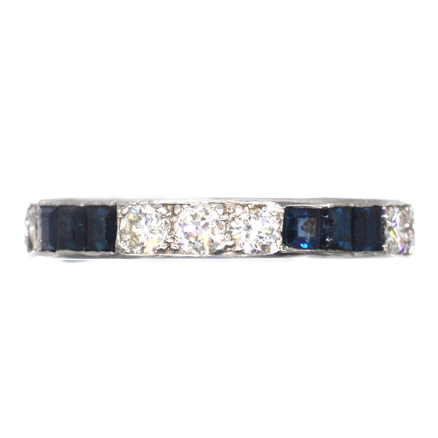 Art Deco platinum eternity ring featuring sapphires and diamonds, symbolizing everlasting love and elegance.