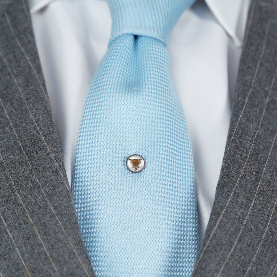 Art Deco reverse intaglio fox tie pin on light blue tie, worn with gray suit, showcasing vintage style and craftsmanship.