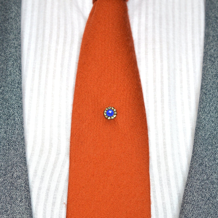 Art Deco rose cut blue sapphire and white paste tie pin on orange tie, offering a stylish and elegant accessory.